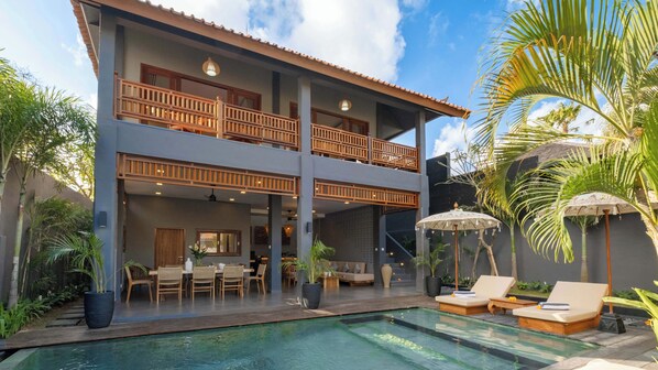 A two-story building with a pool, outdoor seating, and tropical plants. - Villa Alami by Villa Finder (Seminyak)