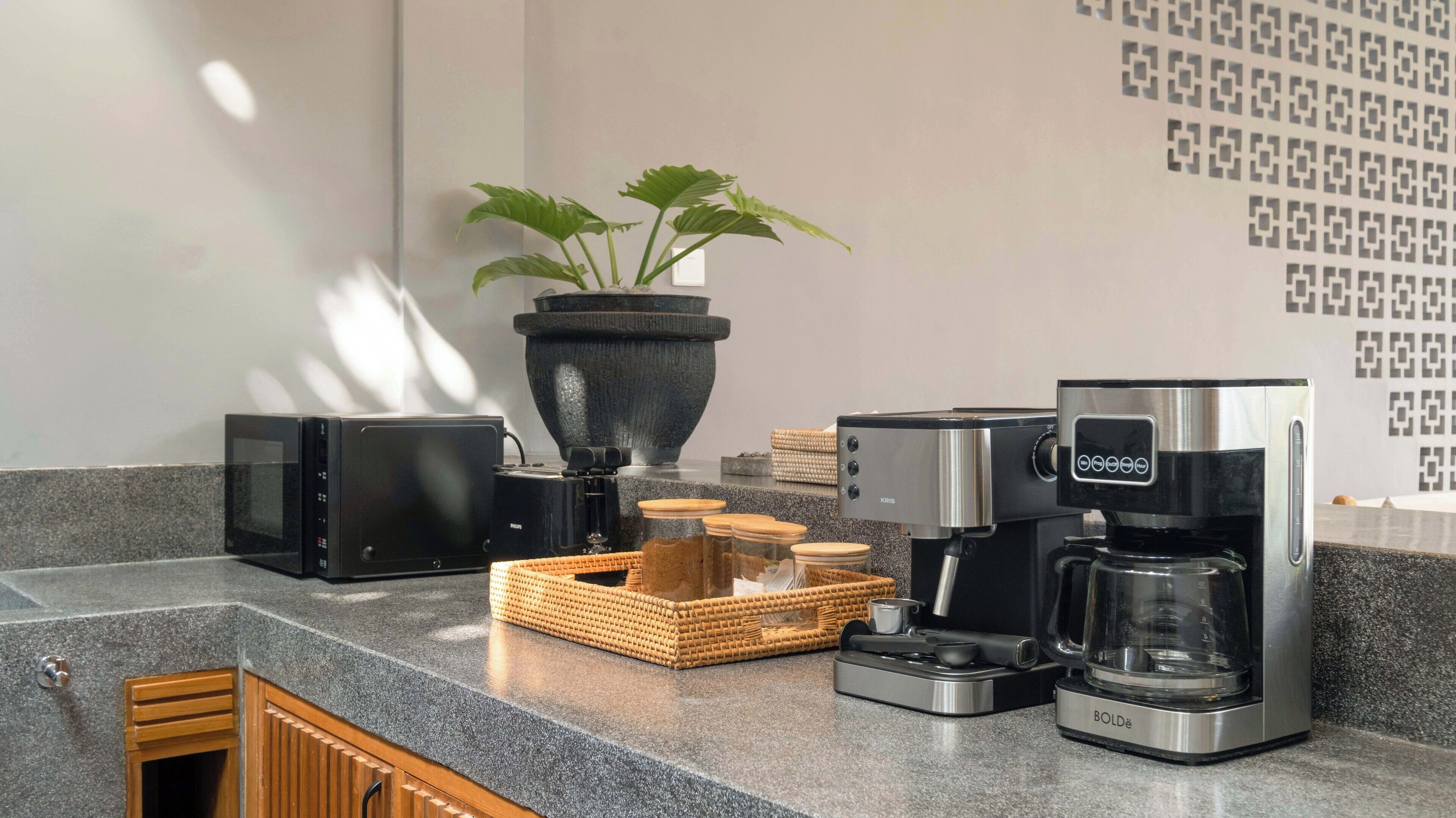 Eine Küchenarbeitsplatte mit Kaffeemaschine, Toaster, Mixer und einer Topfpflanze.