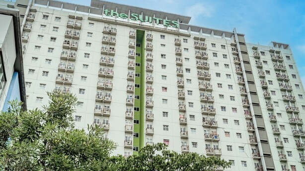 Ein Hochhaus-Hotel mit mehreren Balkonen und einer vertikalen Grünanlage.