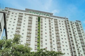 Un hôtel de grande hauteur doté de nombreux balcons et d’un élément vertical végétal.