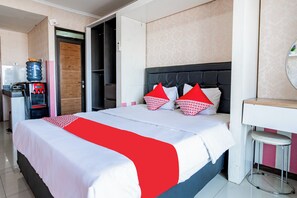 Una habitación de hotel con cama, dispensador de agua, escritorio y espejo.