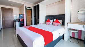 Ein Hotelzimmer mit Bett, Schreibtisch, Spiegel und Wasserspender.