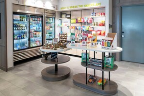 A snack display with a variety of products, a refrigerated section, and a sign that reads 'HOME IS WHERE THE SNACKS ARE.'