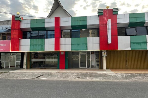 Un edificio con facciata verde e bianca, caratterizzata da una vistosa striscia rossa.