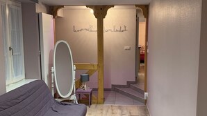 Un dormitorio con una cama, un espejo y una escalera que conduce a otra habitación.
