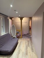 Un dormitorio con una cama, un espejo y una escalera que conduce a otra habitación.