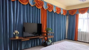 A bedroom with a bed, a TV on a stand, curtains, and a window. - Hailar Dongsheng Luxury Hotel (Hailar Airport Branch) (Hulunbuir)