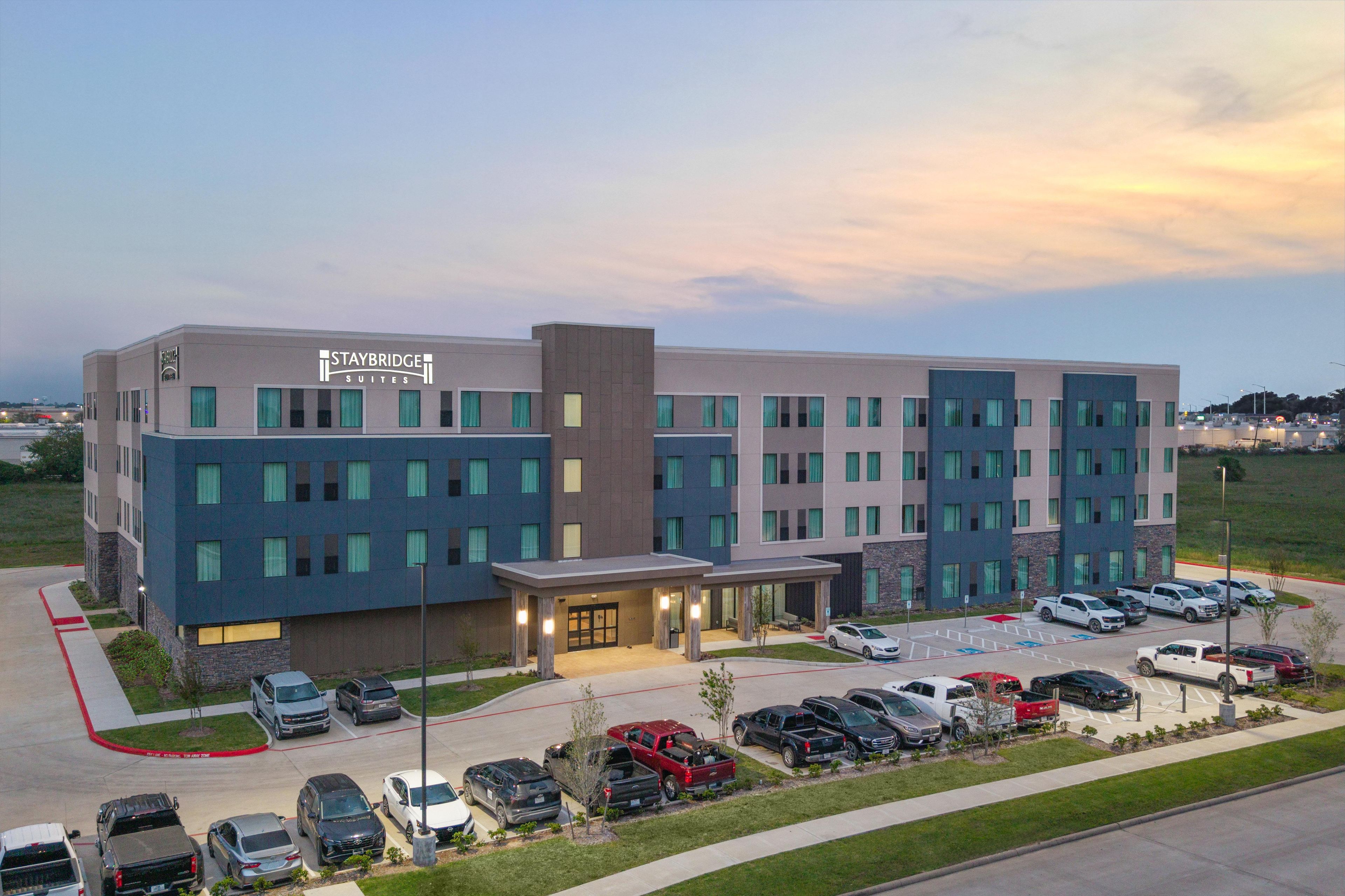 A Staybridge Suites hotel with a modern design, multiple parking spaces, and a well-maintained exterior.