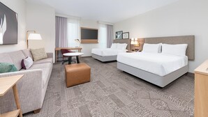 A hotel room with a large bed, a sofa, a small table, and a desk. - Staybridge Suites Port Arthur Mall Area (Port Arthur)