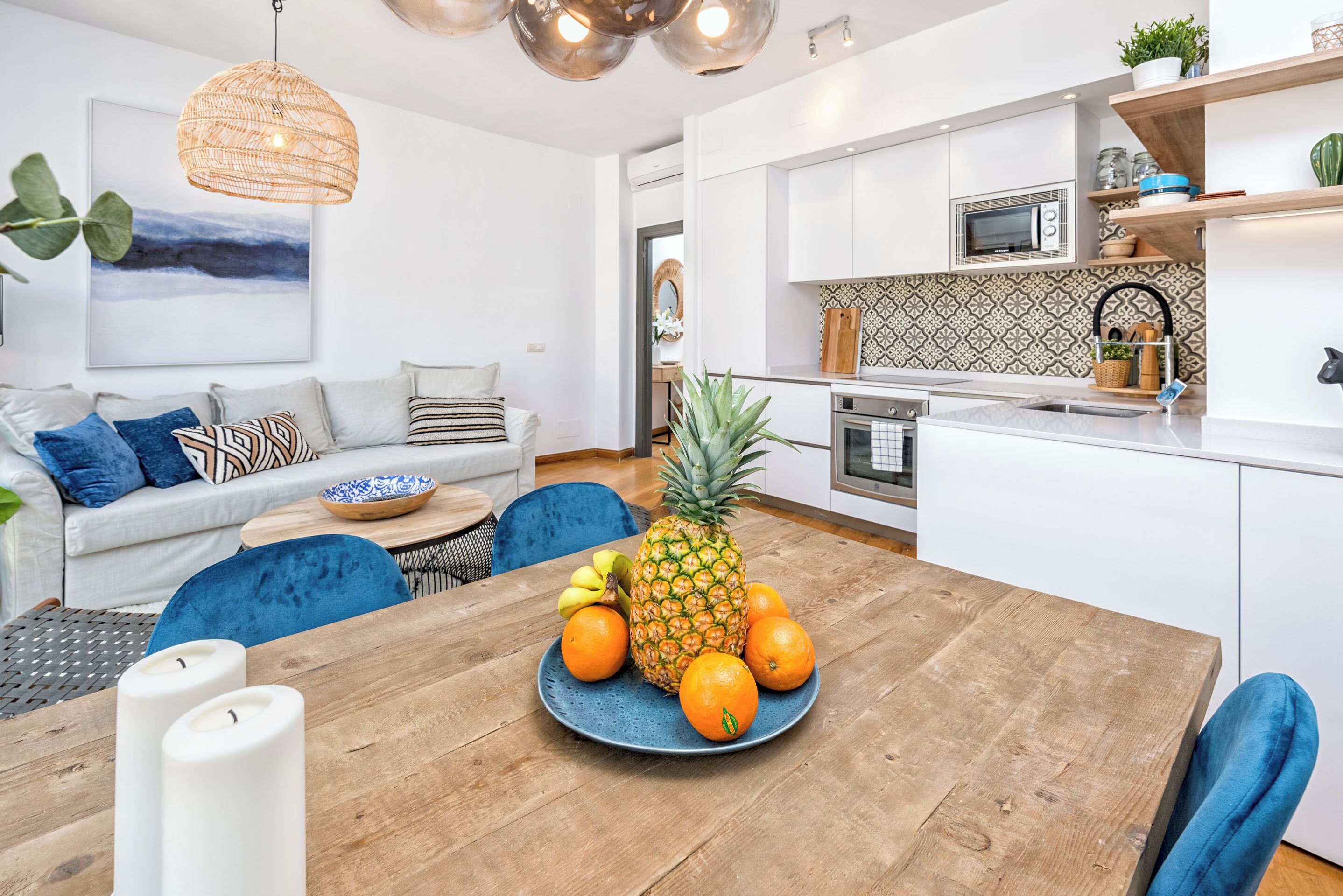 Una cocina moderna con armarios blancos, microondas y un salpicadero decorado.