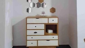 A corner room with a white wall, a wooden cabinet with drawers, and a ceiling-mounted air conditioner. - Luxueux Appartement S+3 Avec Jacuzzi - Confort et Élégance (nabeul)