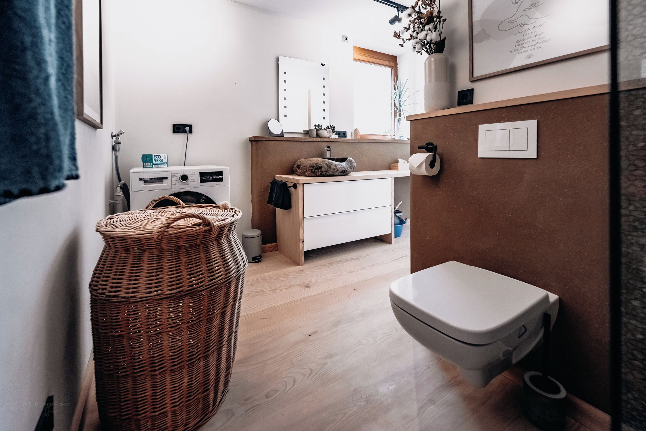 A compact bathroom with a washing machine, a sink with a mirror, and a toilet.