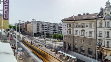 A street view with a tram, buildings, and a Corvin banner.