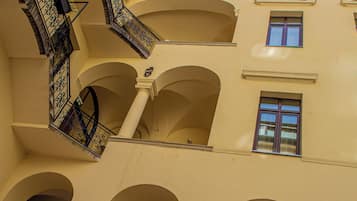 Un intérieur à plusieurs niveaux, agrémenté d’alcôves et de balcons en arc de cercle, et caractérisé par un style architectural homogène, avec des murs de couleur claire et des balustrades décoratives.