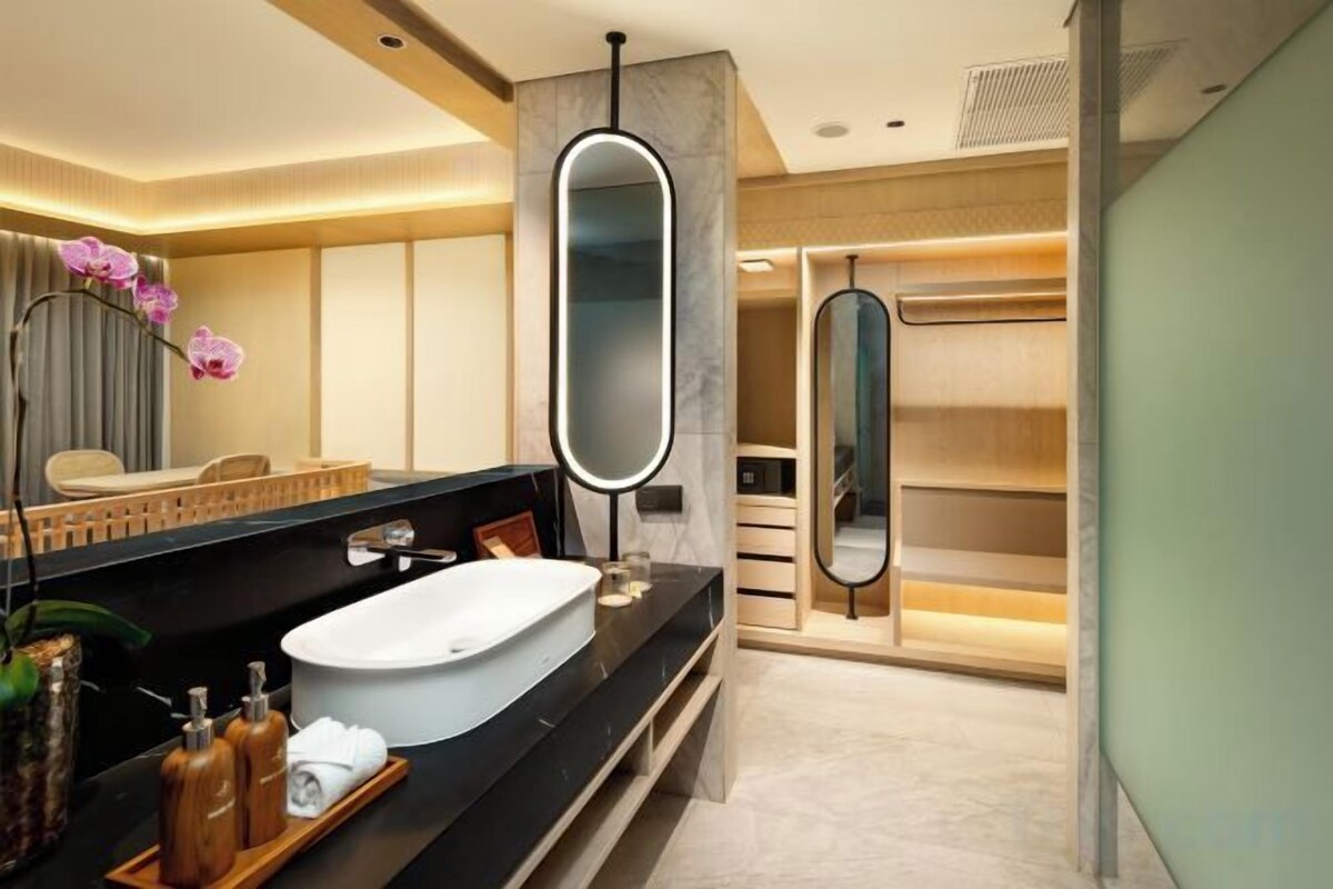 Een moderne badkamer met een ruim bad, een wastafel met spiegel en een douchegedeelte.