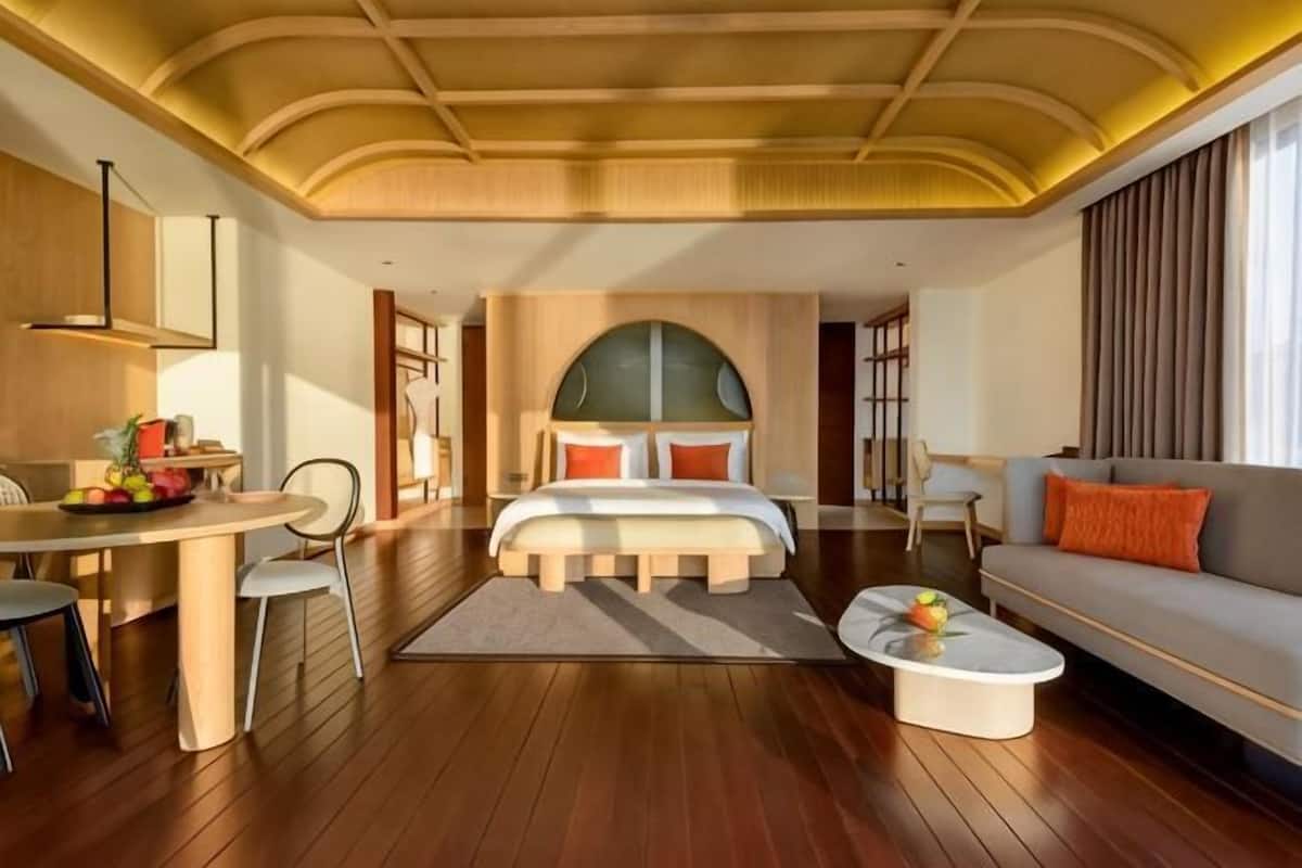 Ein geräumiges Zimmer mit einem großen Bett, einem Sofa, einem Esstisch und einem Couchtisch.