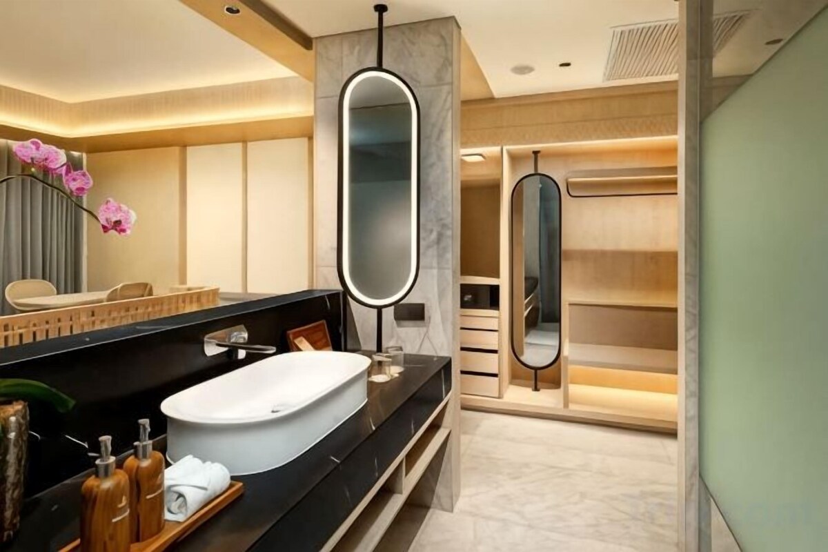 Een moderne badkamer met een groot bad, een wastafel met spiegel en een inloopdouche.