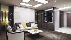 Rebedor modern d'hotel amb un sofà, una taula de cafè i una zona de cuina.