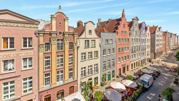 A row of colorful historic buildings with a street in front.