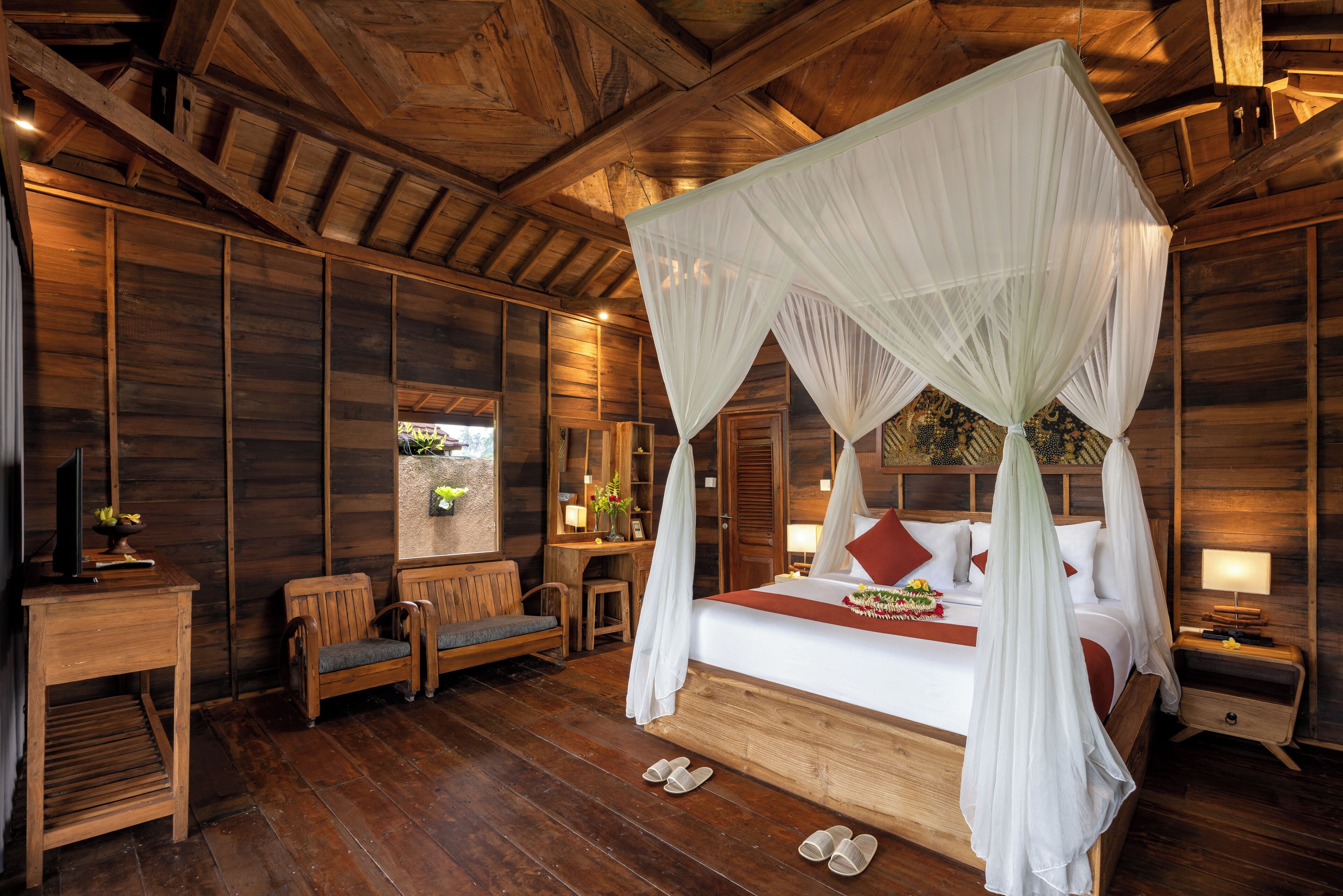 Un dormitorio tipo cabaña de madera con cama con dosel, muebles de madera y un ventanal grande.