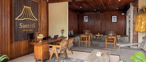 A wooden-floored room with a desk, chairs, and a sofa.