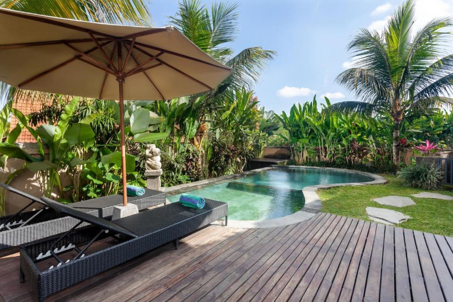 A poolside area with lounge chairs and a wooden deck.