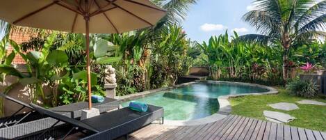 A poolside area with lounge chairs and a wooden deck.