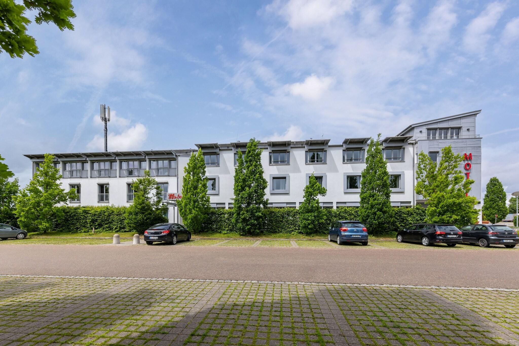 Ein modernes Gebäude mit flachem Dach, zahlreichen Fenstern und einem Schild, das es als Motel kennzeichnet.