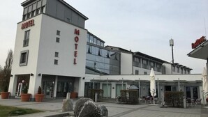 Een modern motel met een tweelaags gebouw, een overdekte buiten zitruimte en een aangelegde entree.