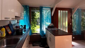 Cozinha moderna com claraboia, ilha grande e vista para o verde lá fora.