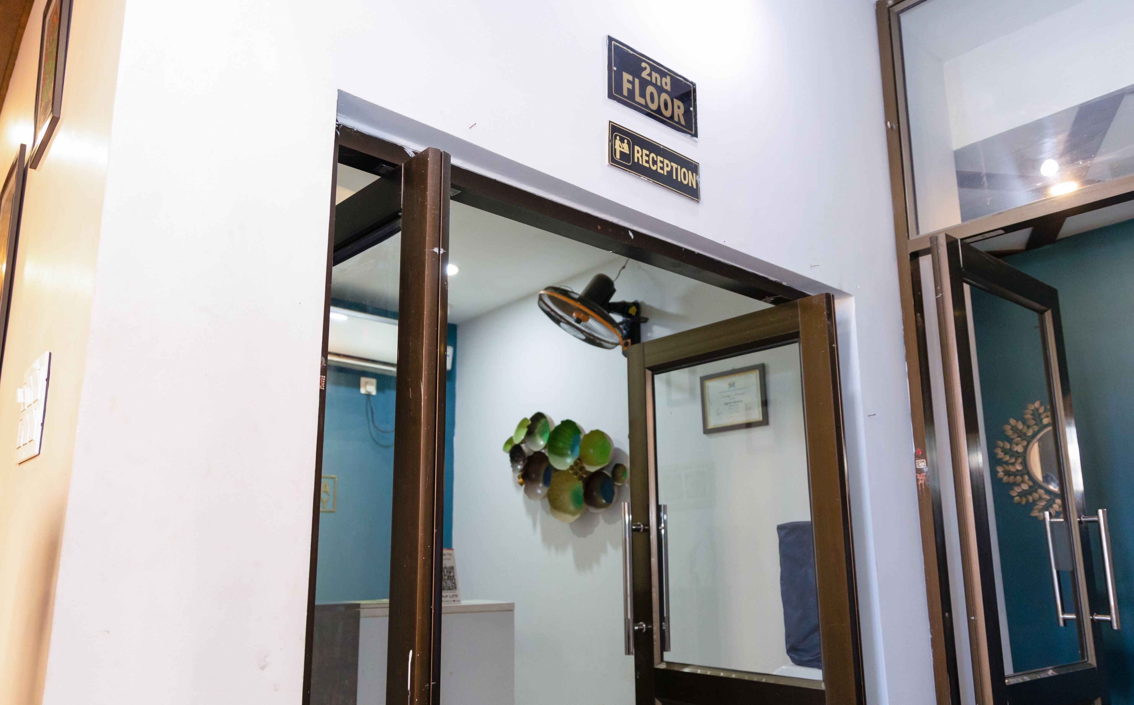 An interior view of a hotel reception area with a sign indicating the 2nd floor and reception.