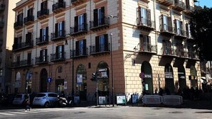 A multi-story building with a classical architectural style, featuring balconies and arched windows. - Palco Rooms&Suites (Palermo)