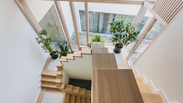 En moderne trappe med trindriller af træ og plantekasser på hver side.