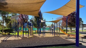 A playground with climbing structures, slides, and a bench. - Rest easy in this cozy, quiet and secure, 2 bedroom unit in Payneham South with no stairs. Linen hire included + Aircon throughout. Easy free parking & wifi too! (Payneham South)