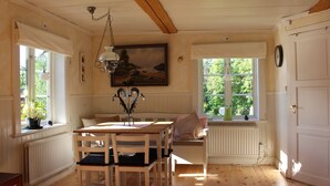 A cozy room with a wooden table, chairs, a bench, and a painting on the wall. - Cozy and spacious traditional Swedish Dala cottage (Dalarnas län)
