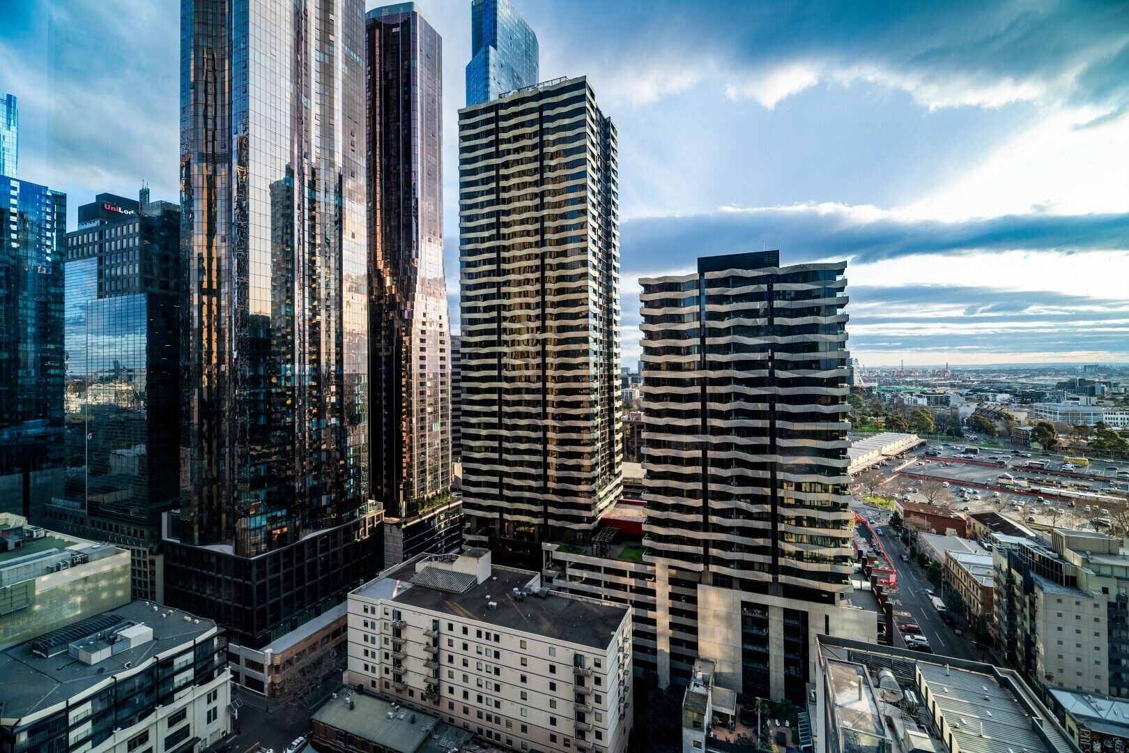 Een hoog gebouwde stedelijke omgeving met moderne wolkenkrabbers, waaronder een opvallend gebouw met een unieke gevel.