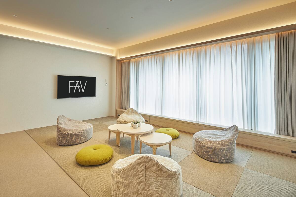 A modern living room with tatami mats, a round table, and bean bags.