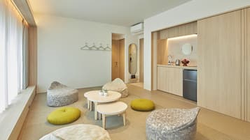 Un salon moderne avec un coin cuisine, comprenant un canapé, une table basse et une table à manger.