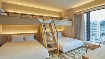 Hotelkamer met twee bedden, een houten trap, een bureau en een groot raam met uitzicht op de stad.