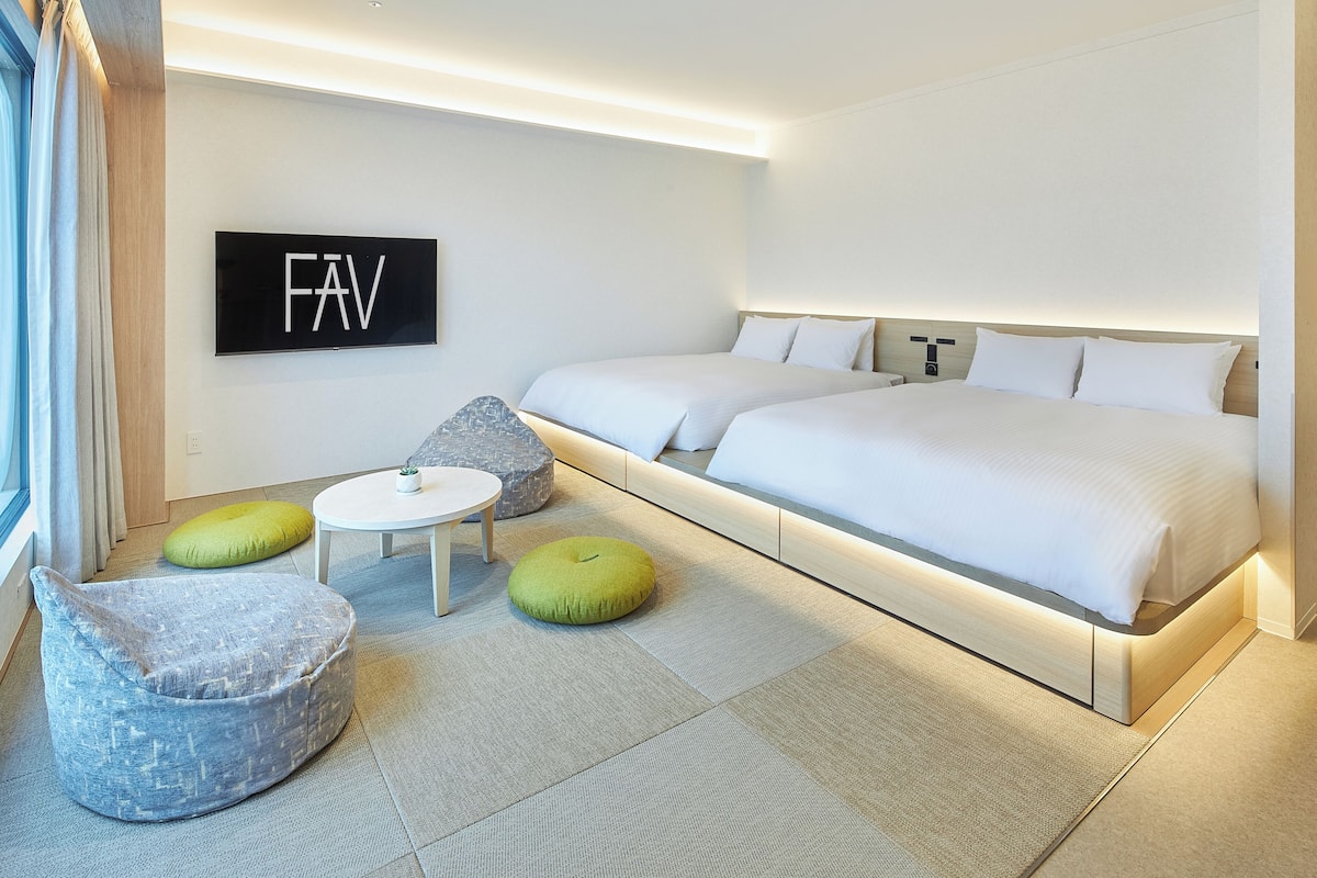 A modern hotel room with a large bed, a small round table, and a bean bag chair.
