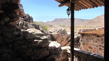 Un edificio de piedra con techo de tejas y vistas a un paisaje montañoso.