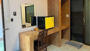 A room with a wooden desk, two monitors, a chair, a mirror, and a sliding door. - OYO 75524 SK Resort (Nuea Khlong)