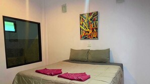 A bedroom with a bed, pillows, a window, and a painting on the wall. - OYO 75524 SK Resort (Nuea Khlong)