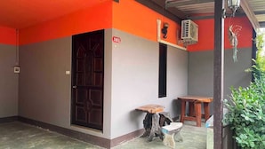 A room with a large wooden door, a small table, and a potted plant. - OYO 75524 SK Resort (Nuea Khlong)