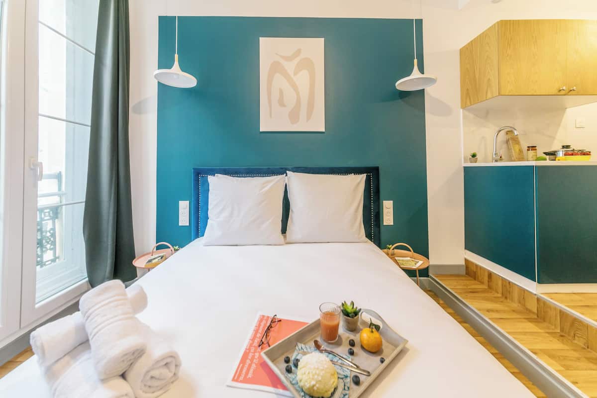 Une chambre d’hôtel avec un lit, un plateau de petit-déjeuner et une vue sur la cuisine.