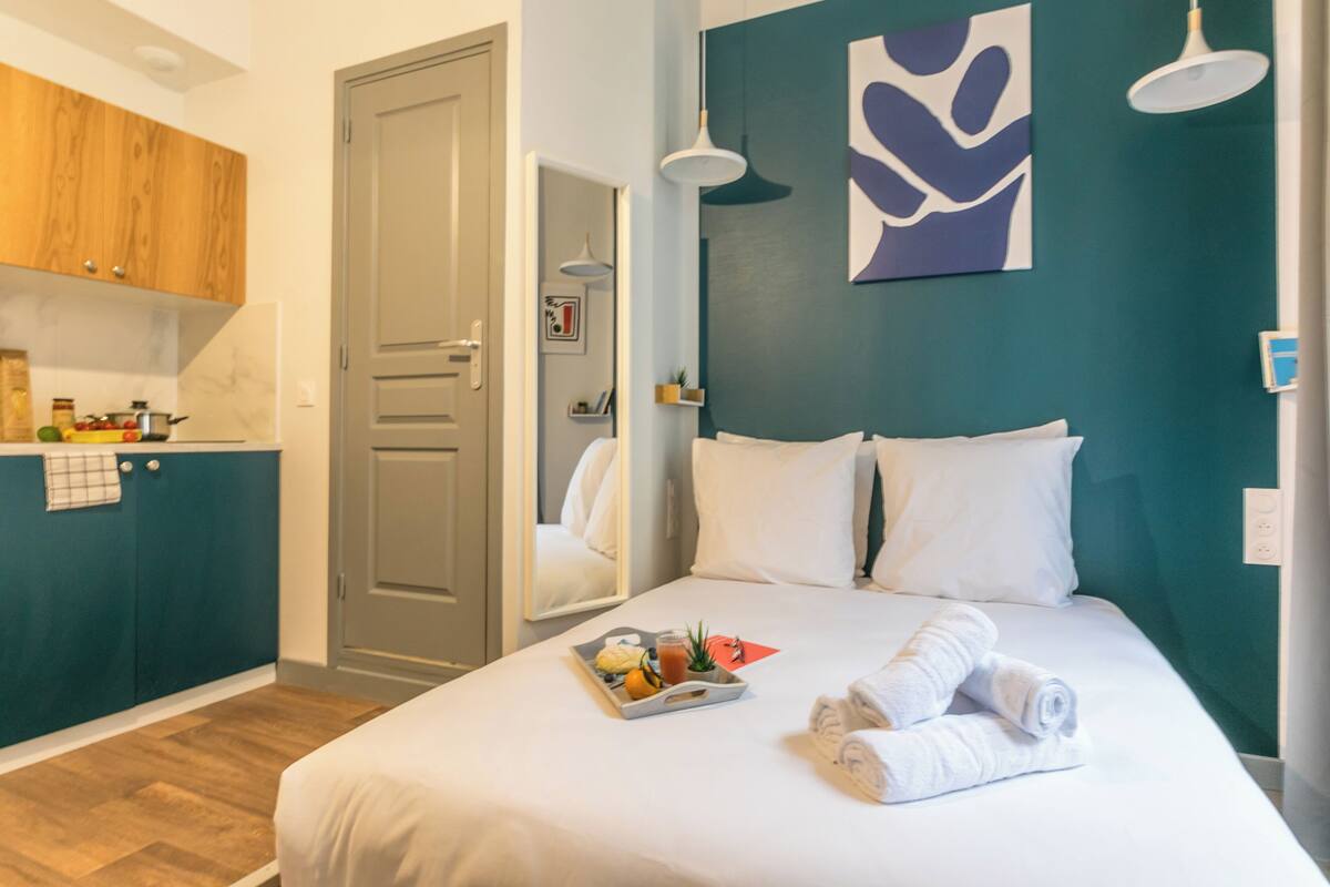 Une chambre d’hôtel avec un lit, un plateau de petit-déjeuner et des serviettes.