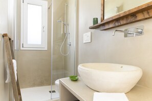 A bathroom with a large vessel sink, a glass shower enclosure, and a wooden shelf above the sink. - Ecofriendly Villa Oliva Blu by Wonderful Italy (Ostuni)