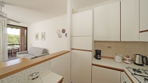 A compact kitchen with white cabinets, a countertop, a gas stove, a coffee maker, and a toaster. - Residence Riviera 43 by Wonderful Italy (Desenzano del Garda)