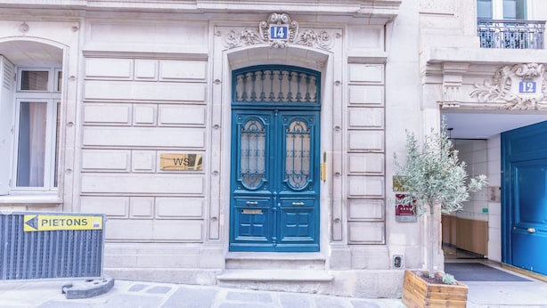 A building with a blue door, numbered 14, and a small tree in a planter. - WS Champs-Elysées - Colomb (Paris)