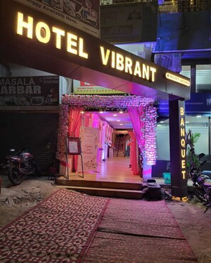 A hotel entrance with a 'Hotel Vibrant' sign, a red carpet, and a staircase leading inside. - Hotel Vibrant Lawn And Banquet (Danapur)